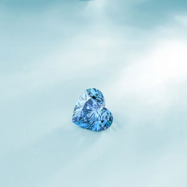 A heart-shaped blue gemstone radiating elegance on a soft light blue background.