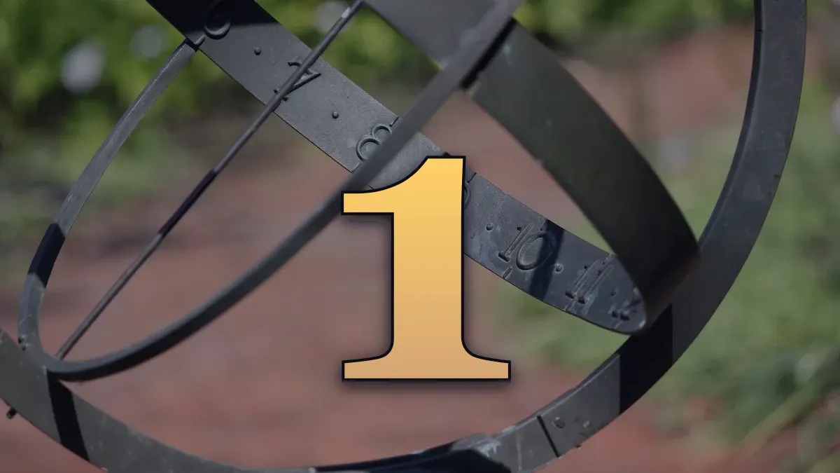 Detailed view of a brass sundial with garden background, showcasing numbers and metal rings.